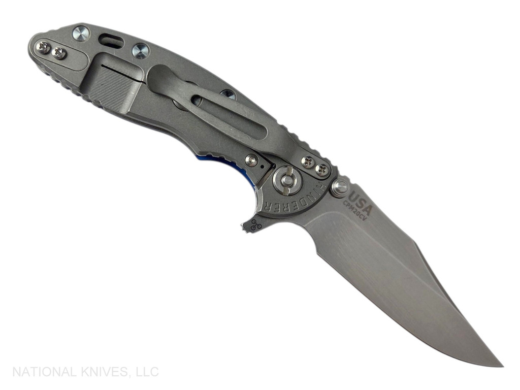 Rick Hinderer Knives XM-18 3.0" Bowie folding knife with thumb stud and flipper tab - shown open lock side.  Stonewash 20CV stainless steel plain edge blade.  Blue - black G-10 handle with Working Finish lock side.  Model KXM30BOW.