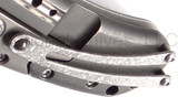 Todd Begg Knives Bodega 2.0 folding knife with flipper tab - shown close up of pocket clip.  2-tone N690 stainless steel plain edge blade.  Gray titanium handle.
For reference only.