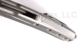 Todd Begg Knives Bodega 2.0 folding knife with flipper tab - shown close up of back spacer.  2-tone N690 stainless steel plain edge blade.  Gray titanium handle.
For reference only.