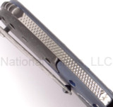 Todd Begg Knives Bodega 2.0 folding knife with flipper tab - shown close up of back spacer.  2-tone N690 stainless steel plain edge blade.  Blue titanium handle.
For reference only.