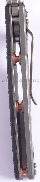 Rick Hinderer Knives Eklipse Tanto folding knife with thumb stud and flipper tab - shown open close up of standoffs.  Stonewash S35VN stainless steel plain edge blade.  Black G-10 handle with Working Finish lock side.  Model K40040TD00.
For reference only.