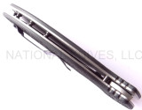 Emerson Knives Aftershock SF folding knife with thumb disk and Emerson Wave - shown closed top view.   Stonewashed 154CM stainless steel plain edge blade.  Black G-10 handle.  Model AFTERSHOCK-SW.
For reference only.