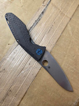 Used Spyderco Drunken folding knife with thumb hole - shown open presentation side.  Satin S90V stainless steel plain edge blade.  Black carbon fiber handle with titanium lock side.  Model C235CFTIP.