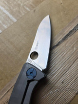 Used Spyderco Drunken folding knife with thumb hole - close up of lock side blade shown.  Satin S90V stainless steel plain edge blade.  Black carbon fiber handle with titanium lock side.  Model C235CFTIP.