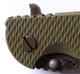 Rick Hinderer Knives Battlefield Pick Up XM-18 3.5" Harpoon Spanto folding knife with thumb stud and flipper tab - close up of presentation side pivot shown.  M390 stainless steel plain edge blade.  OD green G-10 handle with titanium lock side.  Model K25520SP00.
For reference only.