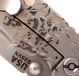 Rick Hinderer Knives Horse Head Logo Fatty XM-18 3.5" Harpoon Tanto folding knife with thumb stud and flipper tab - close up of horse head logo.  Stonewash S35VN stainless steel plain edge blade.  Black G-10 handle with stonewash lock side.  Model K2506SGS00.
For reference only.