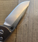 USED Rick Hinderer Knives XM-18 Automatic Spearpoint knife with push button - close up of presentation side blade shown.  Stonewash 20CV stainless steel plain edge blade.  Anodized bronze titanium handle. 