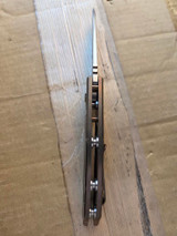 USED Rick Hinderer Knives XM-18 Automatic Spearpoint knife with push button - close up of top view of handle.  Stonewash 20CV stainless steel plain edge blade.  Anodized bronze titanium handle. 