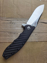 Used Zero Tolerance 0562CF folding knife with flipper lever and thumb studs - shown open presentation side.  Satin CPM-20CV stainless steel plain edge blade.  Black carbon fiber handle with titanium lock side.  Model 0562CF.