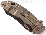 Rick Hinderer Knives Vintage Series XM-18 3.5" Skinner folding knife with thumb stud and flipper tab - shown closed lock side.  Black O-1 steel plain edge blade.  Textured Walnut handle with Battle Green titanium lock side.  Model K2042S0VT00.
For reference only.