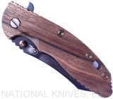 Rick Hinderer Knives Vintage Series XM-18 3.5" Skinner folding knife with thumb stud and flipper tab - shown closed presentation side.  Black O-1 steel plain edge blade.  Smooth Walnut handle with Battle Green titanium lock side.  Model K2042S0VT00.
For reference only.