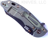 Rick Hinderer Knives Vintage Series XM-18 3.5" Skinner folding knife with thumb stud and flipper tab - shown closed lock side.  Black O-1 steel plain edge blade.  Smooth Walnut handle with Battle Green titanium lock side.  Model K2042S0VT00.
For reference only.