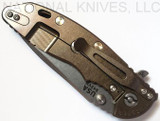 Rick Hinderer Knives XM-18 3.5" Spanto folding knife with thumb stud and flipper tab - shown closed lock side.  Stonewash S45VN stainless steel plain edge blade.  Black G-10 handle with stonewash bronze lock side.  Model K2002SGS00.