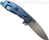 Rick Hinderer Knives XM-18 3.5" Slicer folding knife with thumb stud and flipper tab - shown open lock side.  Stonewash 20CV stainless steel plain edge blade.  Black G-10 handle with stonewash blue titanium lock side.  Model K2012SGS00.