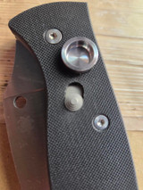 Used Spyderco Autonomy 2 automatic knife with button blade release - close up of button lock shown in unlocked position with blade closed.  Satin LC200N plain edge blade.  Black G-10 handle.  Model C165GP2.