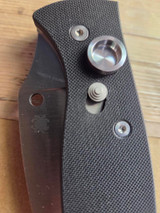 Used Spyderco Autonomy 2 automatic knife with button blade release - close up of button lock shown in locked position with blade closed.  Satin LC200N plain edge blade.  Black G-10 handle.  Model C165GP2.