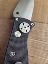 Used Spyderco Autonomy 2 automatic knife with button blade release - close up of pocket clip side pivot shown.  Satin LC200N plain edge blade.  Black G-10 handle.  Model C165GP2.