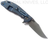 Rick Hinderer Knives XM-24 Bowie folding knife with thumb stud and flipper tab - shown open lock side.  Working Finish 20CV stainless steel plain edge blade.  Blue - black G-10 handle with Battle Blue lock side.  Model KXM40BO.