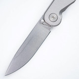 Tactile Knife Co Rockwall folding knife with a thumb stud - close up of blade and pivot.  Stonewashed MagnaCut stainless steel plain edge blade.  Titanium handle.  Model 20-RT-MC01-TT01.