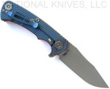Rick Hinderer Knives Project X Clip Point folding knife with flipper tab - shown open lock side.  Working Finish MagnaCut stainless steel plain edge blade.  Orange G-10 handle with Battle Blue lock side.  Model KPXSPEMC.
