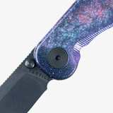 Tactile Knife Co Seasonal Release Deep Space Rockwall folding knife with thumb stud - shown close up of pivot.  Black MagnaCut stainless steel plain edge blade.  Deep Space themed titanium handle.
For reference only.