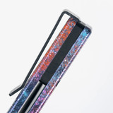 Tactile Knife Co Seasonal Release Deep Space Rockwall folding knife with thumb stud - shown close up of back spacer.  Black MagnaCut stainless steel plain edge blade.  Deep Space themed titanium handle.
For reference only.