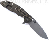 Rick Hinderer Knives Skinny XM-18 3.5" Slicer folding knife with thumb stud and flipper tab - shown open lock side.  Working Finish MagnaCut stainless steel plain edge blade.  Black G-10 handle with Battle Bronze lock side.  Model KXM35SKSL.