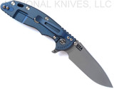 Rick Hinderer Knives Skinny XM-18 3.5" Slicer folding knife with thumb stud and flipper tab - shown open lock side.  Working Finish MagnaCut stainless steel plain edge blade.  Blue - black G-10 handle with Battle Blue lock side.  Model KXM35SKSL.