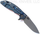 Rick Hinderer Knives Skinny XM-18 3.5" Slicer folding knife with thumb stud and flipper tab - shown open lock side.  Working Finish MagnaCut stainless steel plain edge blade.  Orange G-10 handle with Battle Blue lock side.  Model KXM35SKSL.