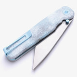 Tactile Knife Co Seasonal Release Icefall Rockwall folding knife with a thumb stud - shown partially open pocket clip side.  Stonewashed MagnaCut stainless steel plain edge Tanto blade.  Multi colored coated titanium handle.  Model 20-RT-MCTN-ICE.
For reference only.