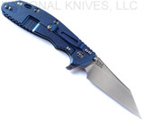 Rick Hinderer Knives Skinny XM-24 Wharncliffe folding knife with thumb stud and flipper tab - shown open lock side.  Stonewash S45VN stainless steel plain edge blade.  OD green G-10 handle with stonewash blue lock side.  Model KXM40SKWC.