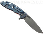 Rick Hinderer Knives XM-18 Skinny Slicer with thumb stud and flipper tab - shown open lock side.  Working Finish Magnacut stainless steel, hollow ground, plain edge blade.  Orange G-10 handle with Battle Blue lock side. 
