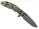 Rick Hinderer Knives XM-18 Skinny Slicer with thumb stud and flipper tab - shown open lock side.  Working Finish Magnacut stainless steel, hollow ground, plain edge blade.  Black G-10 handle with Battle Green lock side. 
