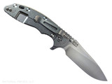 Rick Hinderer Knives XM-18 Skinny Slicer with thumb stud and flipper tab - shown open lock side.  Stonewash Magnacut stainless steel, hollow ground, plain edge blade.  Black G-10 handle with stonewash lock side. 