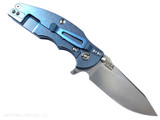 Rick Hinderer Knives Jurassic Hollow Grind Slicer folding knife with flipper tab - shown open lock side.  Stonewash MagnaCut stainless steel plain edge blade.  Blue G-10 handle scale with stonewash blue titanium lock side.  Model KJURSLHO.