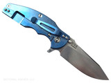Rick Hinderer Knives Jurassic Hollow Grind Slicer folding knife with flipper tab - shown open lock side.  Stonewash MagnaCut stainless steel plain edge blade.  Translucent Green G-10 handle scale with stonewash blue titanium lock side.  Model KJURSLHO.