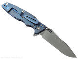 Rick Hinderer Knives Skinny Eklipse Slicer folding knife with flipper tab - shown open - lock side.  Working Finish 3.5" hollow grind MagnaCut stainless steel plain edge blade.  Black G-10 handle scale with Battle Blue lock side.  Model KEK35SKSLHO