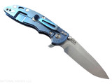 Rick Hinderer Knives XM-18 3.5" Spanto folding knife with thumb stud and flipper tab - shown open lock side.  Stonewash 20CV stainless steel plain edge blade.  Black G-10 handle with stonewash blue lock side.  Model KXM35SPA.