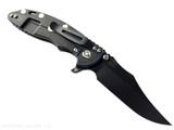 Rick Hinderer Knives XM-18 3.5" Bowie folding knife with thumb stud and flipper tab - shown open lock side.  Battle Black MagnaCut stainless steel plain edge blade.  OD green G-10 handle with Battle Black lock side.  Model KXM35BOWMC.