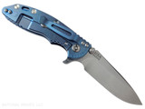 Rick Hinderer Knives XM-18 3.25" Spear Point folding knife with thumb stud and flipper tab - shown open lock side.  Stonewash S45VN stainless steel plain edge blade.  Black G-10 handle with stonewash blue lock side.  Model KXM325SPE.
