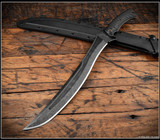 RMJ Tactical Wyvern short sword - shown atop sheath tip pointed lower left.  Acid Etched 3V steel plain edge blade.  Black G-10 handle scales.  Model 3V-WY-AE-BK.