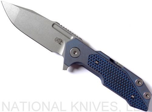 Rick Hinderer Knives Full Track Spanto folding knife with flipper tab - shown open presentation side.  Working Finish S35VN stainless steel plain edge blade.  Blue - black G-10 handle with Battle Blue titanium lock side.  Model K200TSTGW00.
For reference only.