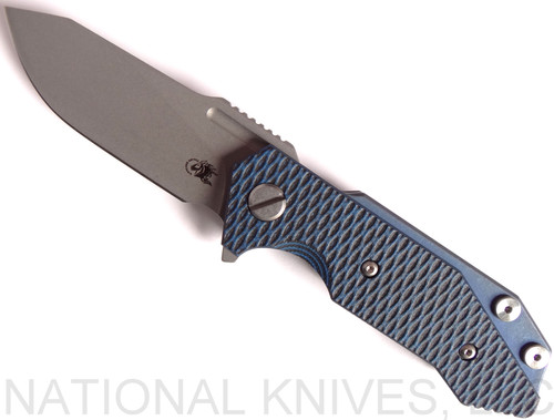 Rick Hinderer Knives Half Track Slicer folding knife with flipper tab - shown open presentation side.  Stonewash 20CV stainless steel plain edge blade.  Blue - black G-10 handle with Battle Blue titanium lock side.  Model K2009SGS00.