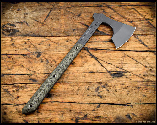RMJ Tactical 3V Syndicate Raven tomahawk - shown out of sheath obverse.  Smoke Gray Cerakote CPM-3V steel plain edge head.  Dirty Olive G-10 handle.
For reference only.