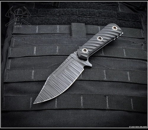RMJ Tactical UCAP fixed blade knife - shown out of sheath reverse.  Textured black Cerakote Nitro-V stainless steel plain edge blade.  Black G-10 handle.