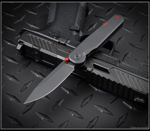 Tactile Knife Co Seasonal Release Stealth folding knife with thumb stud - shown open presentation side.  Black MagnaCut stainless steel plain edge blade.  Stealth themed titanium handle.