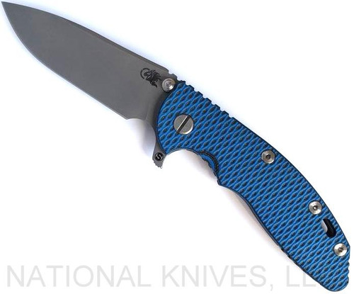 Rick Hinderer Knives Skinny XM-18 3.5" Slicer folding knife with thumb stud and flipper tab - shown open presentation side.  Working Finish MagnaCut stainless steel plain edge blade.  Blue - black G-10 handle with Battle Bronze lock side.  Model KXM35SKSL.