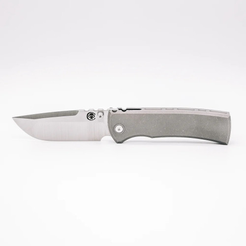 Chaves Knives Integral Redencion 229 folding knife featuring a thumb stud - shown open presentation side.  Belt Satin M390 stainless steel drop point style plain edge blade.  Titanium handle.  Model CK-1C1-1A1A-1A0!