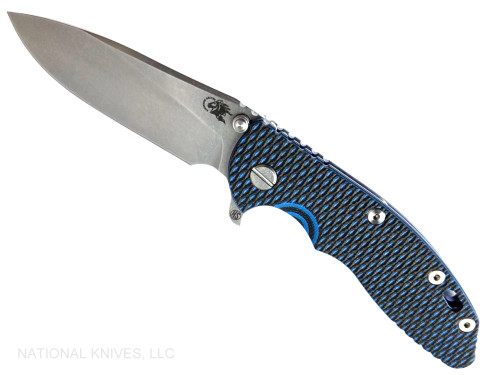 Rick Hinderer Knives XM-18 Skinny Slicer with thumb stud and flipper tab - shown open presentation side.  Stonewash Magnacut stainless steel, hollow ground, plain edge blade.  Blue - Black G-10 handle with stonewash blue lock side. 