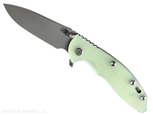 Rick Hinderer Knives XM-18 Skinny Slicer with thumb stud and flipper tab - shown open presentation side.  Working Finish Magnacut stainless steel, hollow ground, plain edge blade.  Translucent Green G-10 handle with Battle Green lock side. 